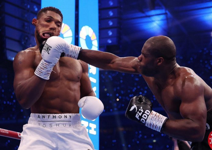 Dubois delivers a knockout punch to Anthony Joshua, causing him to fall to the ground in their boxing match at Wembley Stadium.