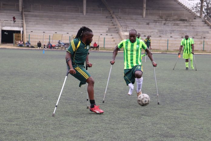 Hashim Kamau playing in an amputee football match, displaying focus and determination as he controls the ball.