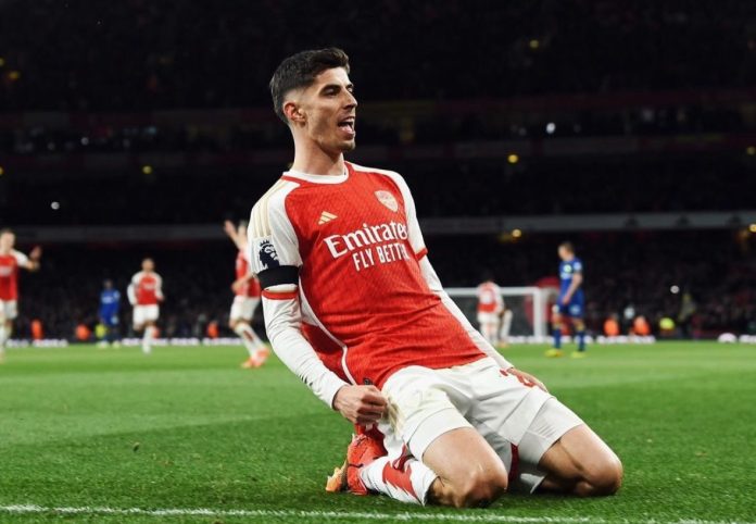 arsenal Kai Havertz celebrating a goal sliding on his knees with his fist clenched during a Premier League match.