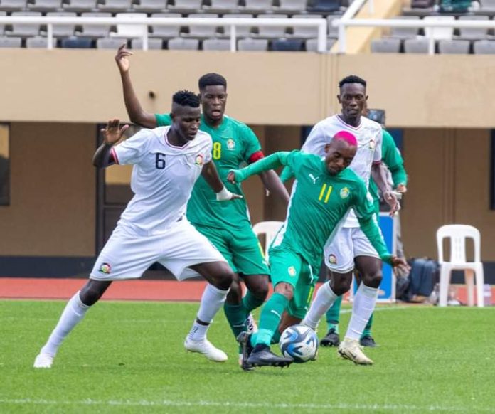 Anthony Akumu in a tussle against Khama Billiat of Zimbabwe during First leg Clash at Mandela Stadium in Uganda