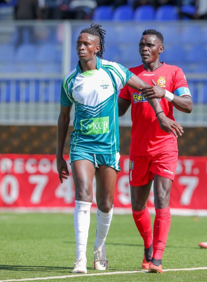 Francis Kahiro anticipates the ball as David Ochieng looks on during a Kenya Premier League against Kenya Police FC at the Dandora Stadium. PHOTO/KCB