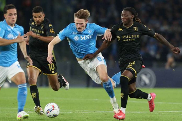 Napoli's Scott McTominay (centre) fights for the ball with Genoa's Junior Messias-Carlo Hermann / AFP