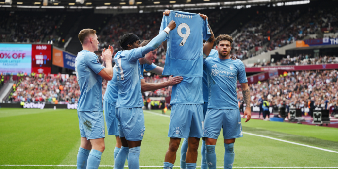 ChatGPT said: Morgan Gibbs-White holds up Taiwo Awoniyi’s jersey in a show of support as Nottingham Forest players celebrate a goal against West Ham at London Stadium.(Photo by Alex Broadway/Getty Images)