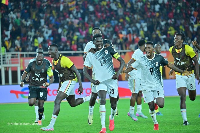 Uganda Cranes players celebrate Rogers Torach’s stoppage-time penalty that sealed a 3-3 draw with South Africa and confirmed their place in the CHAN 2024 quarterfinals at Mandela National Stadium